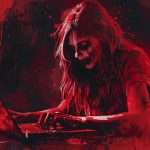 A person with a ghoulish, zombie-like appearance is working on a laptop in an artistic scene with intense red tones and paint splatters.